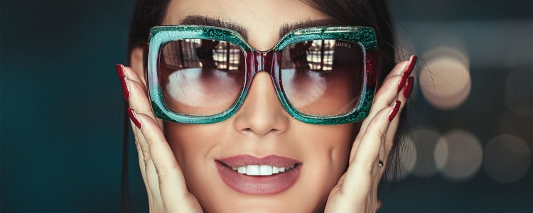 professional young woman wearing green sparkly sunglasses from Gucci