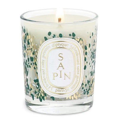 White candle with a glass container and floral design on the label