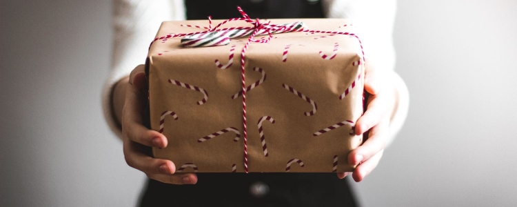 woman holding out a wrapped gift