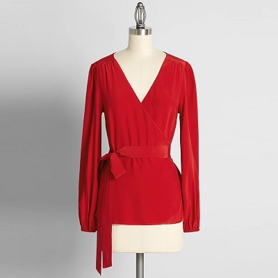A red wrap top on a dress form 