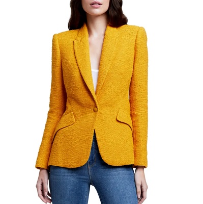 A white woman with brown hair (face partially cropped) wearing a yellow blazer, white shirt, and jeans (legs partially cropped)