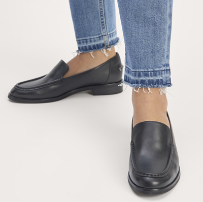 woman in jeans wears black loafers