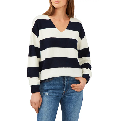 model wearing a stripey V-neck sweater with blue jeans. 