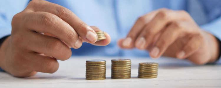 woman's hands with light brown skin, stacking coins