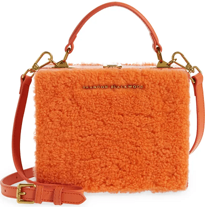 boxy crossbody trunk bag coated in dyed orange shearling