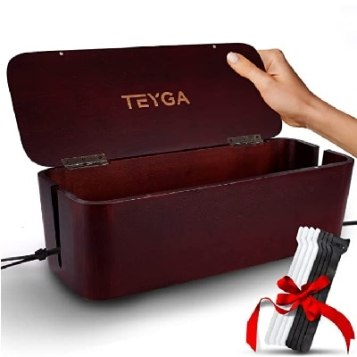 A woman's hand touching a dark brown bamboo cord/cable box with a white background; there are black and white cable ties held together with a red ribbon