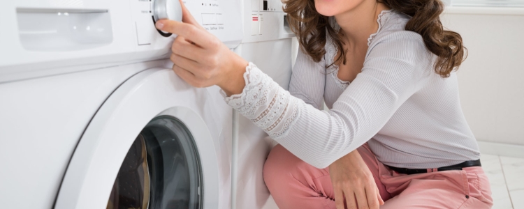 A person sitting in front of a washer
