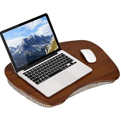 A brown bamboo lap desk with a tan cushion, with a laptop on top and a white mouse