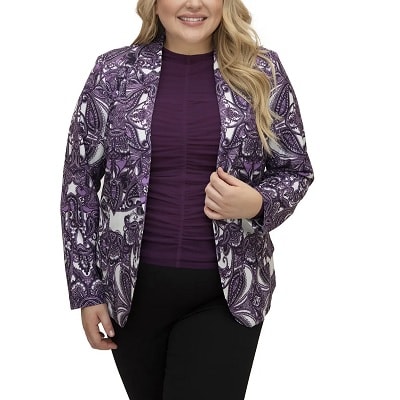 A woman with long blonde hair wearing a purple top, purple paisley blazer, and black pants