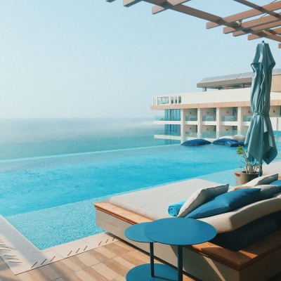 beautiful infinity pool, as seen from inside a cabana with blue pillows