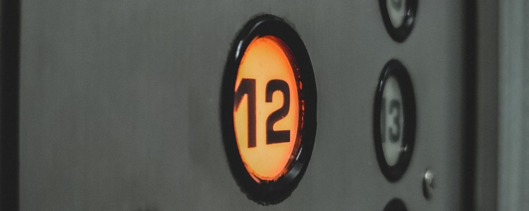 elevator buttons; 12 is lit up orange. 
