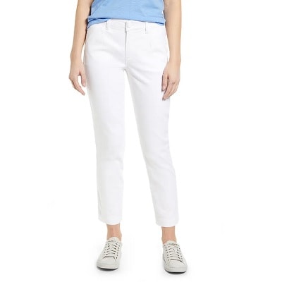 A woman wearing a blue top and white pants with white sneakers