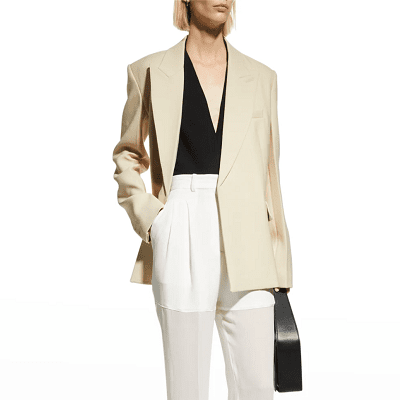 model wears beige boyfriend blazer, black top with a deep V, and white trousers that turn into mesh mid-thigh (no, we don't get it either) 