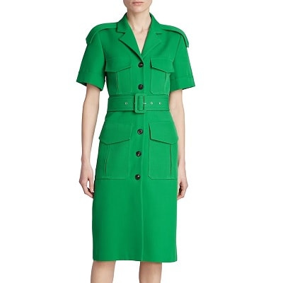 A woman wearing a green utility dress with four pockets and a belt