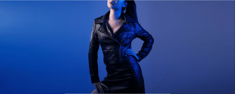 woman poses in zippered leather jacket and leather miniskirt