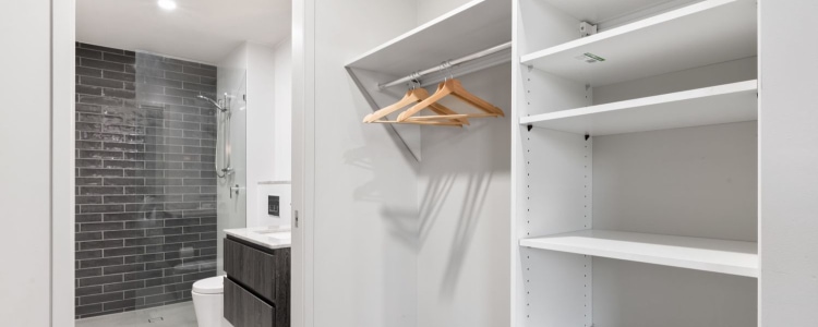 view of an emptied closet just outside of a minimalist bathroom