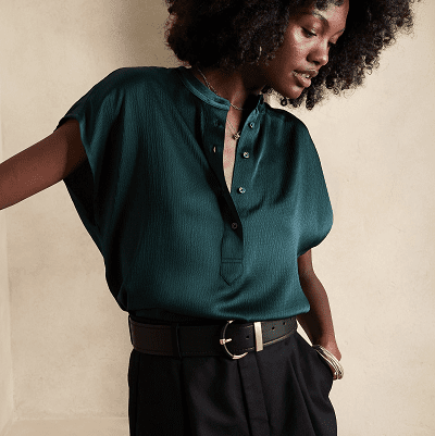 woman in dark green short-sleeve collarless blouse with a button half-placket