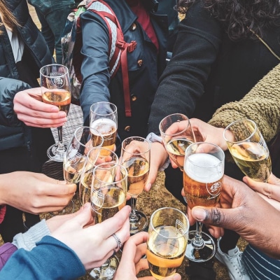 a group of people are clinking champagne glasses together; only arms and hands are visible in the picture