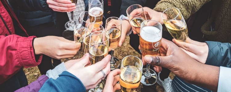 a group of people are clinking champagne glasses together; only arms and hands are visible in the picture