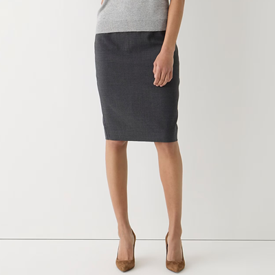 woman wears dark gray skirt, light gray sweater, and caramel suede heels