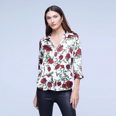 A woman wearing a floral blouse and black pants