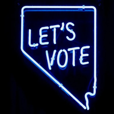 neon sign reads "LET'S VOTE"