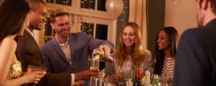 group of people toast drinks at their work holiday party at someone's house