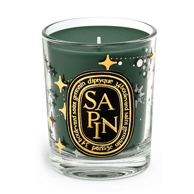 green limited edition Diptyque candle; it has stars and dots on the glass and reads SAPIN