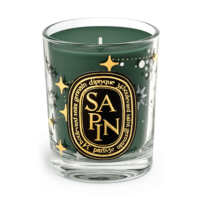 green limited edition Diptyque candle;  there are stars and dots on the glass and it says SAPIN