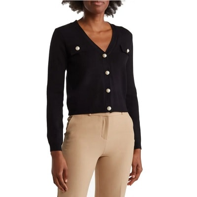 A woman with a black cardigan and tan pants