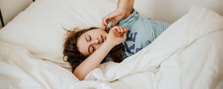 woman yawns in bed