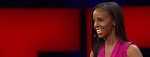 Sarah Lewis giving a TED talk in front of a red background