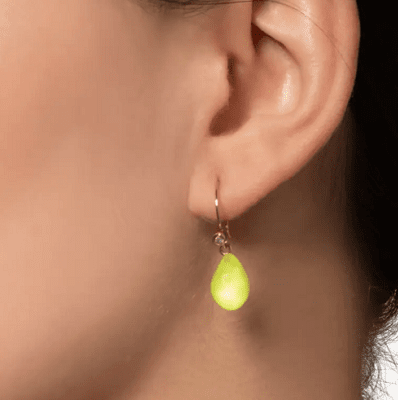 woman wears neon yellow teardrop-shaped earring