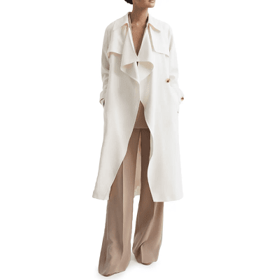 woman wears oversized white trench coat with drapey lapels