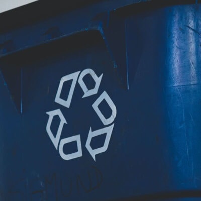 blue dumpster with recycling symbol on it