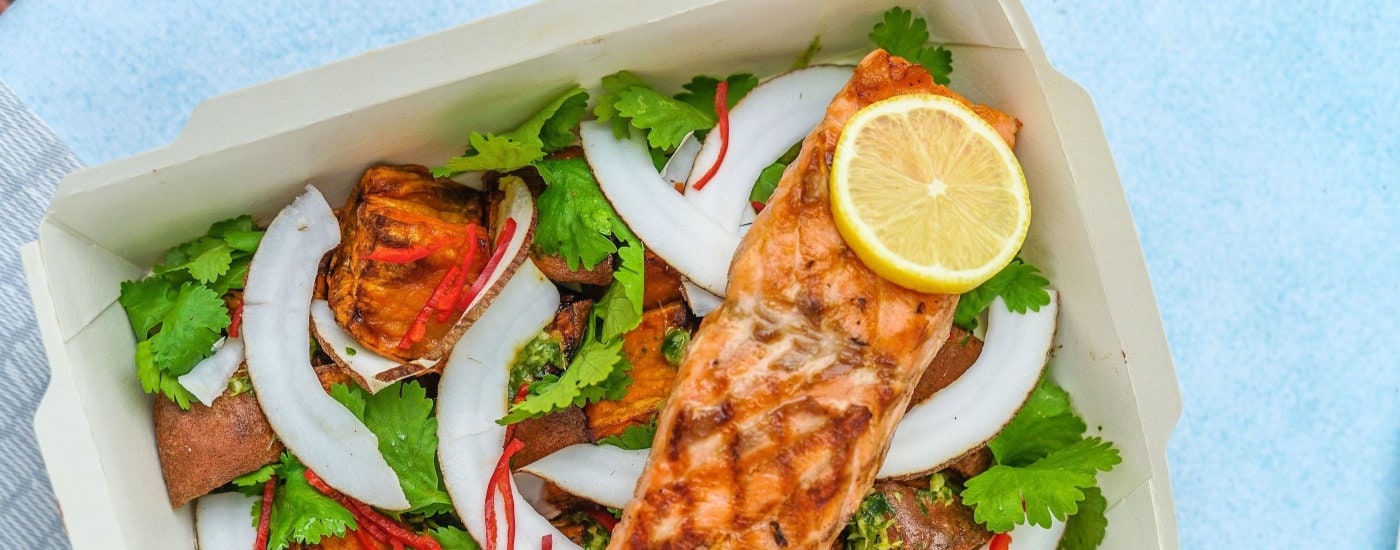 salmon over salad in a takeout container
