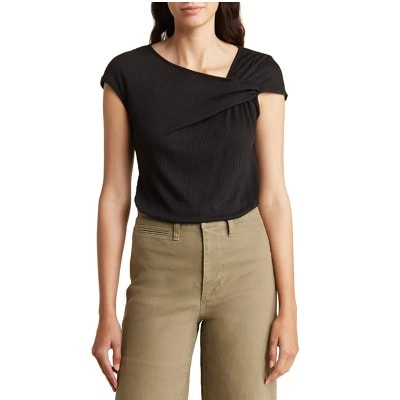 A woman wearing khaki pants and a black top