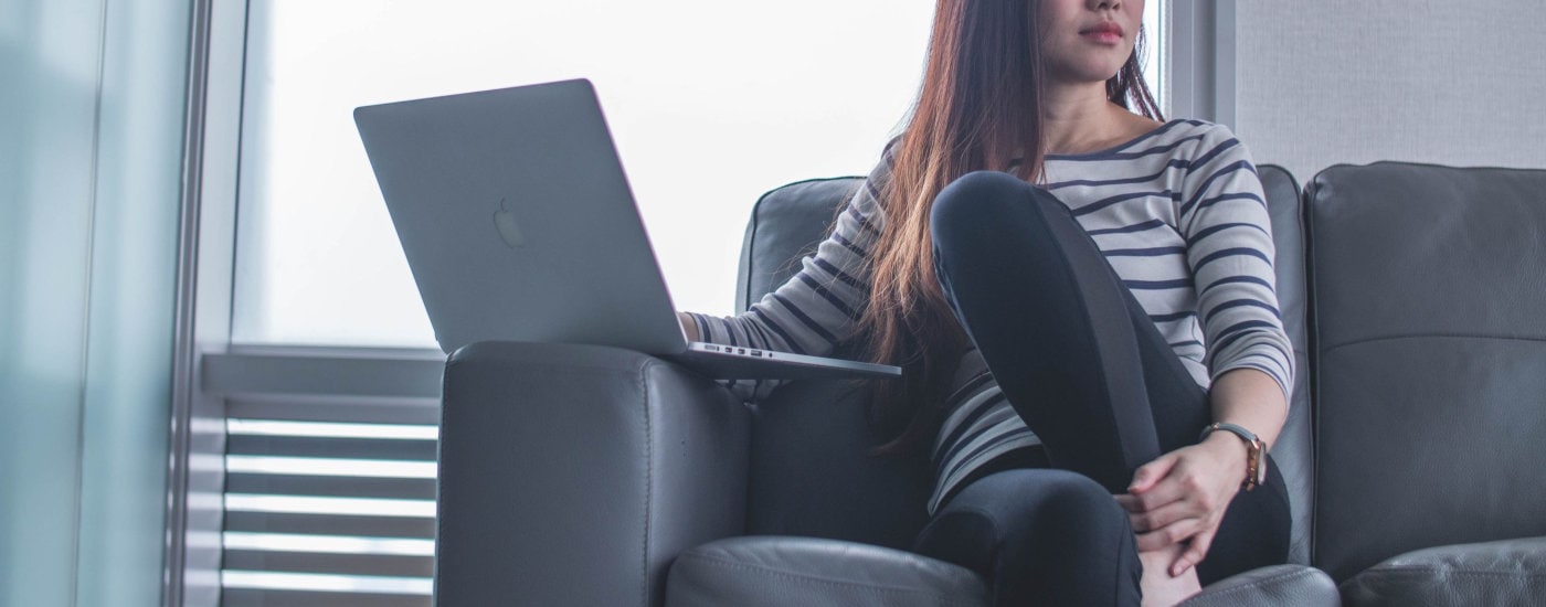 young chic professional woman ponders whether the tone in her email is correct