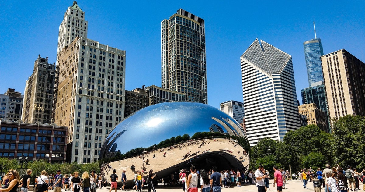 A photo of The Bean and the Chicago skyline with crowds of people