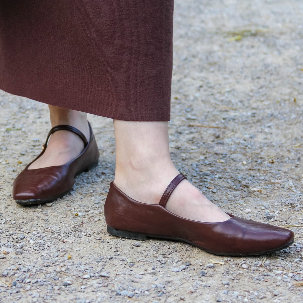 a woman wears stylish burgundy Mary Jane flats for work