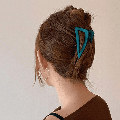 woman wears dark teal green claw clip in her reddish brown hair