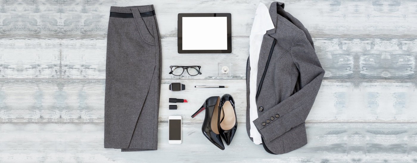 flat lay showing gray pencil skirt and gray suit jacket, white blouse, black heels, red lipstick, and other 