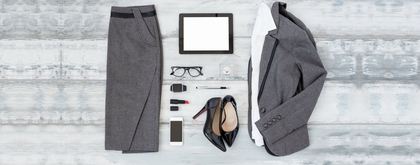 Plain floor showing gray pencil skirt and gray suit jacket, white blouse, black heels, red lipstick and more. 