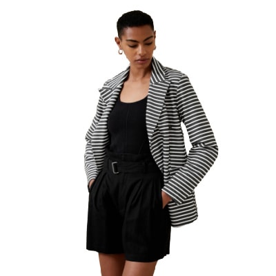 A woman wearing a black and white striped blazer and a black dress