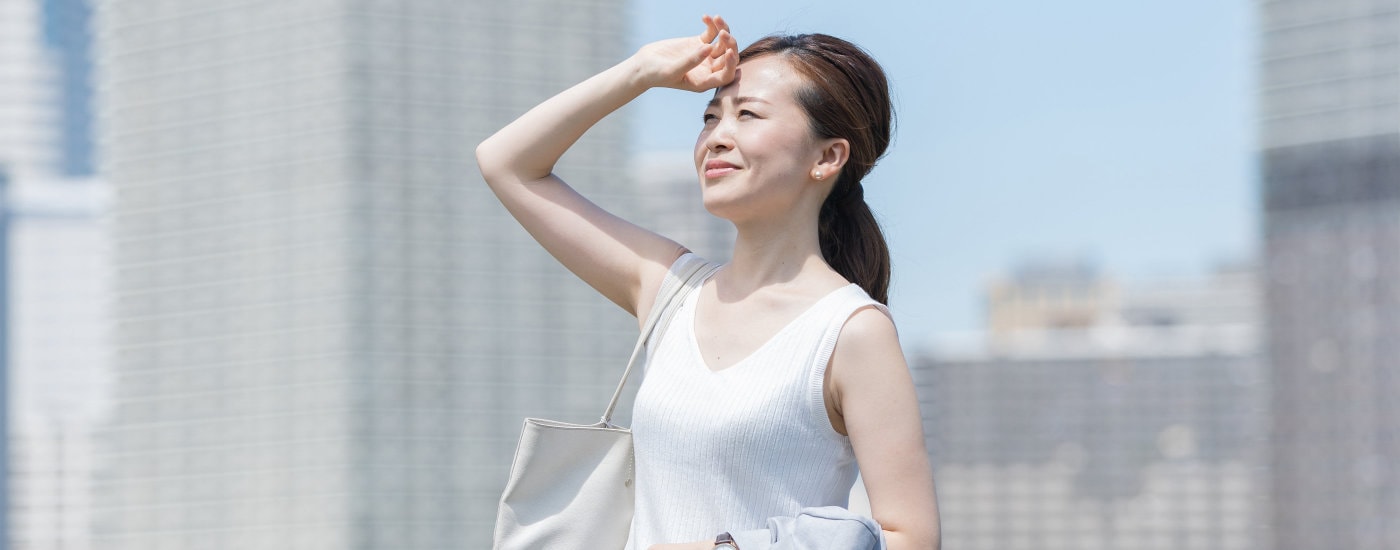 Asian business woman wiping sweat from her forehead in summer heat