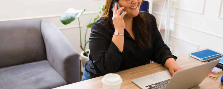 confident stylish plus-sized woman works at a desk and wonders where to get plus-size work clothes for her office