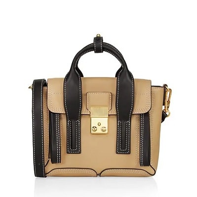 A tan leather satchel with black straps and trim