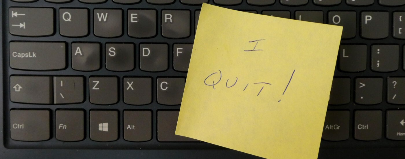 black keyboard with yellow post-it note on it that reads 