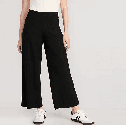 high waisted black pull-on pants with wide slightly cropped legs; model wears white sneakers with black stripes and black soles and a beigeish fitted top
