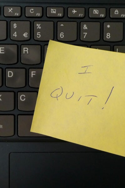 black keyboard with yellow post-it note on it that reads "I QUIT!"